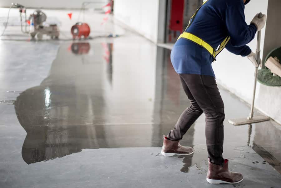 Worker cleaning a polished concrete flooring in a commercial building