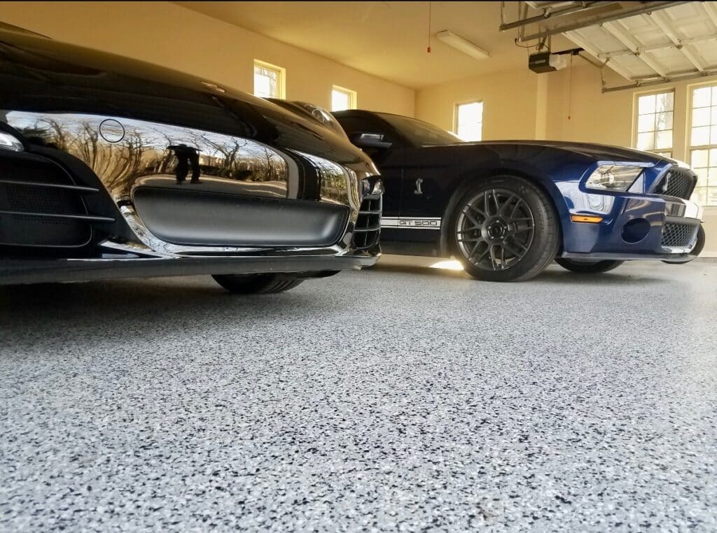 Flake epoxy garage flooring in a residential garage with sports cars parked and clean, high-contrast finish.